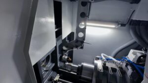 Automated processing using a Swiss-type lathe coupled with a vibratory bowl feeder robotic arm